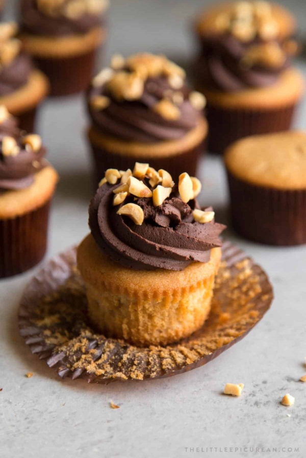 peanut butter cupcakes frosted with whipped chocolate ganache and topped with chopped peanuts.