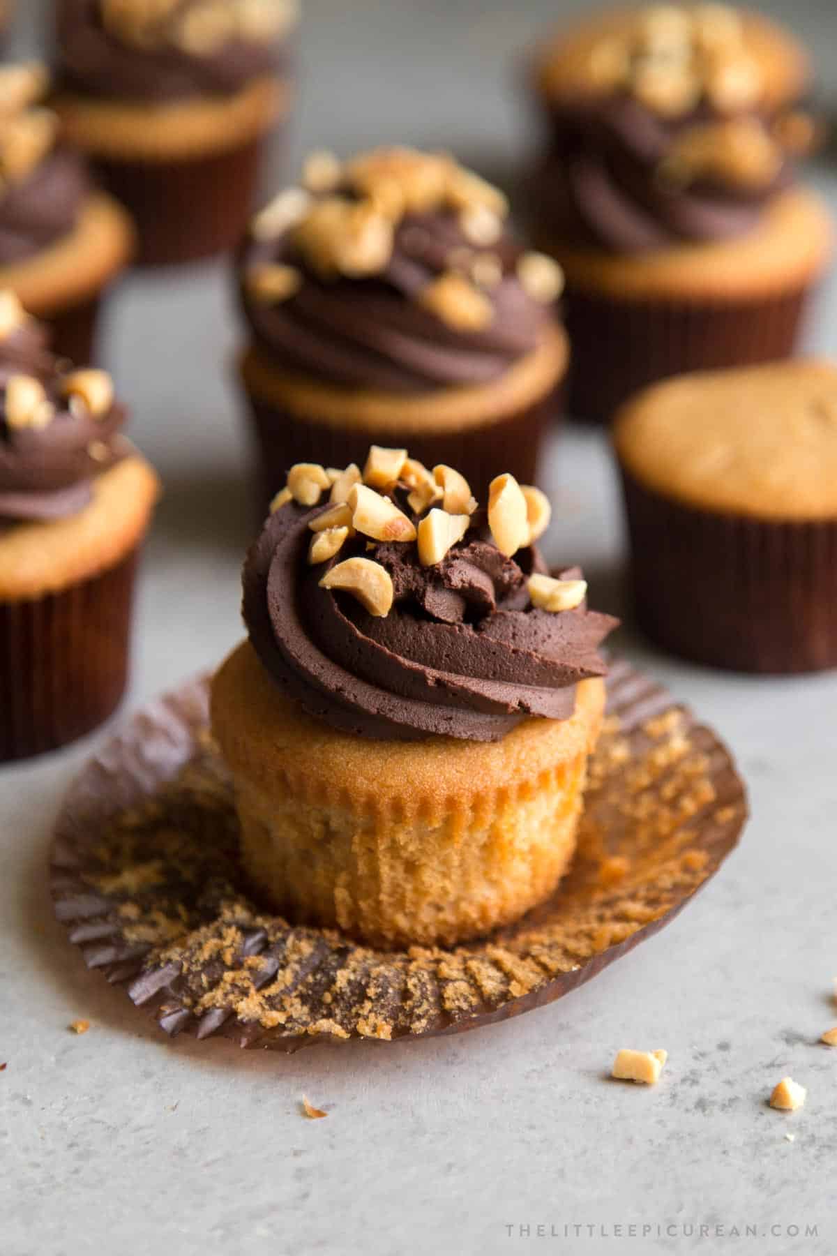 peanut butter cupcakes frosted with whipped chocolate ganache and topped with chopped peanuts.