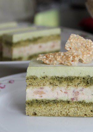 a slice of matcha red bean mousse cake on decorative white tea plate.