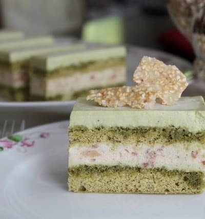a slice of matcha red bean mousse cake on decorative white tea plate.