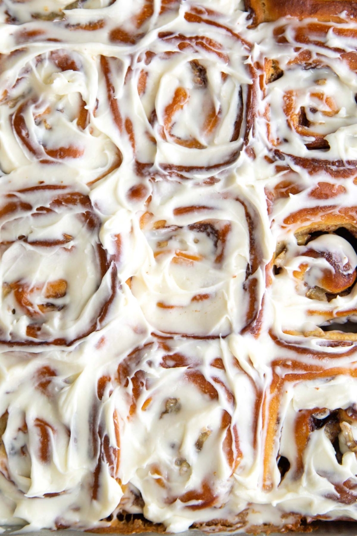 cream cheese glaze banana cinnamon rolls in rectangle baking pan.