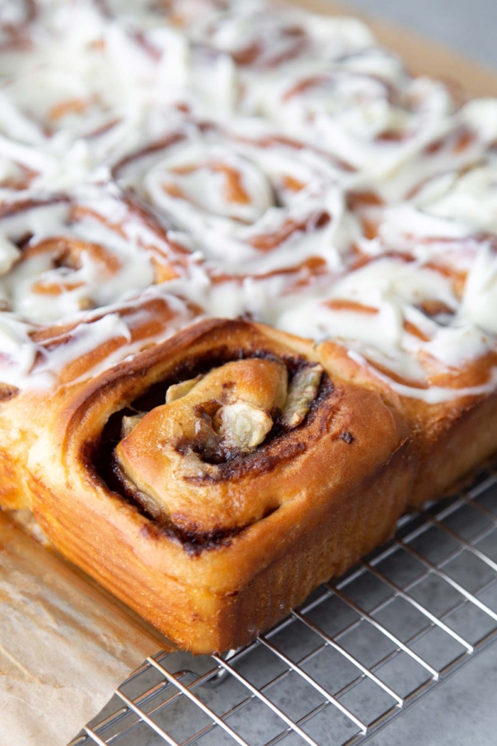 close up of unfrosted banana cinnamon roll on wire rack.