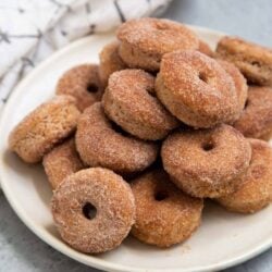 pile of baked mini donuts in serving plate.