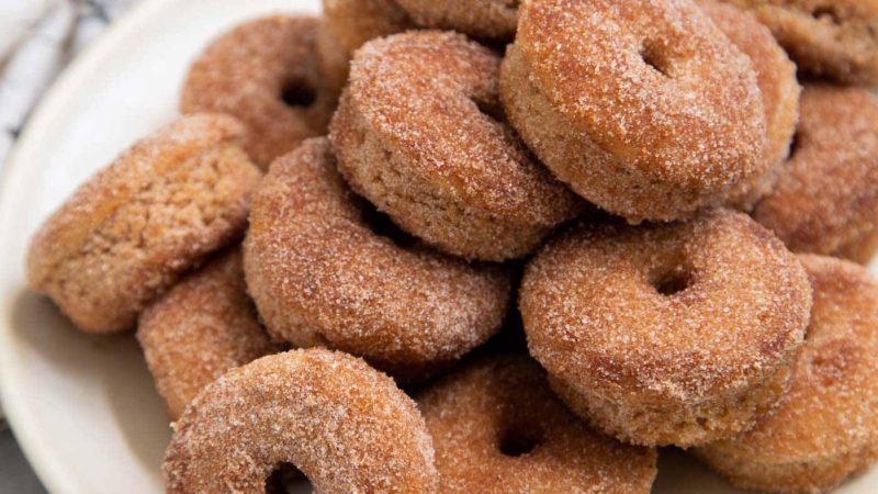 pile of baked mini donuts in serving plate.