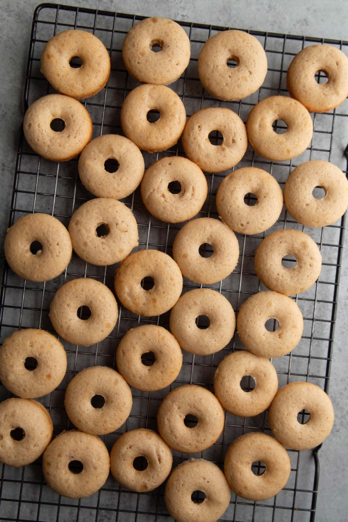 baked mini donuts arranged on cooling rack.