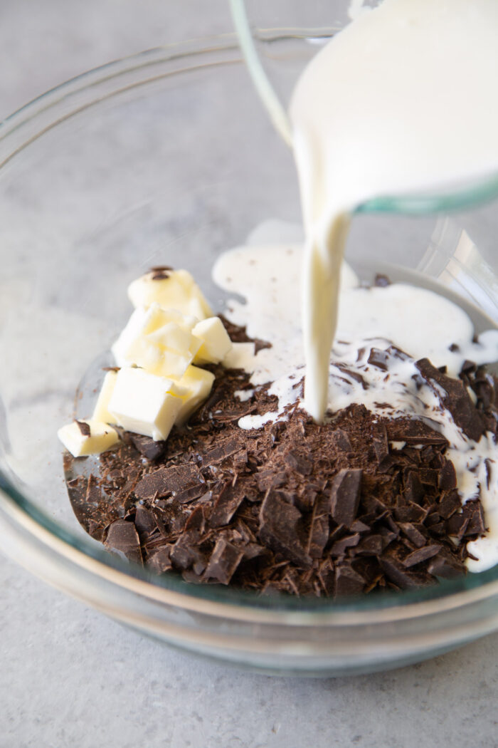 pour hot cream over chopped chocolate, butter, and corn syrup.