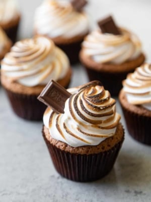 graham cracker cupcakes topped with toasted meringue topping garnished with milk chocolate bar.