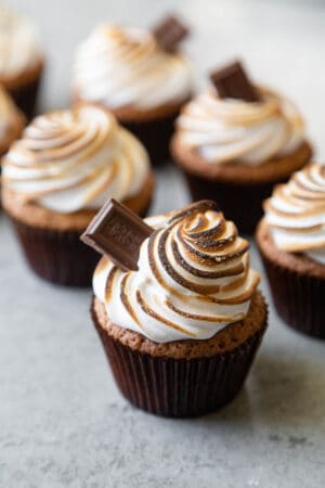graham cracker cupcakes topped with toasted meringue topping garnished with milk chocolate bar.