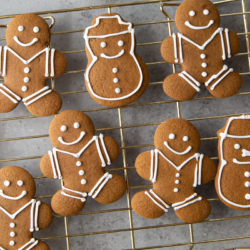 assorted gingerbread cookie cutouts on wire rack.