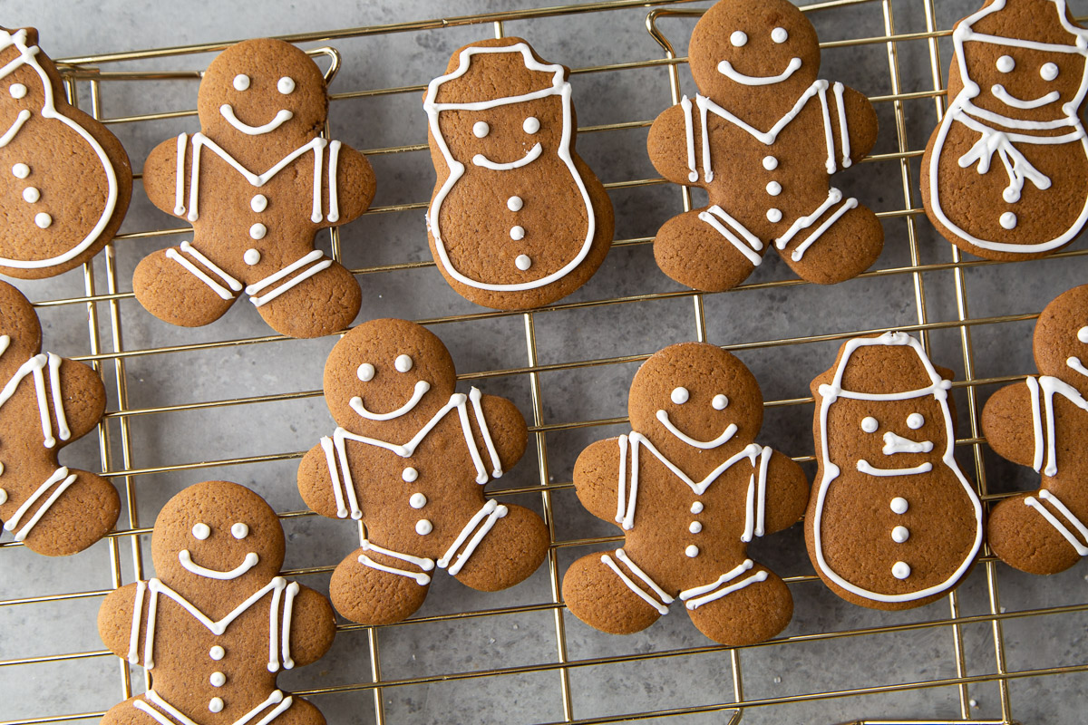 assorted gingerbread cookie cutouts on wire rack.