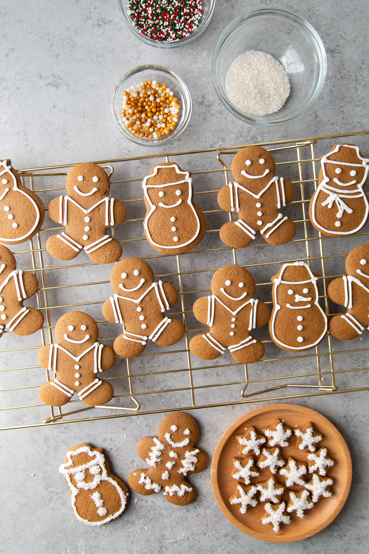 a variety of gingerbread people and gingerbread snowmen decorated with royal icing on wire rack.