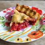 slice of strawberry pie on decorative floral plate.
