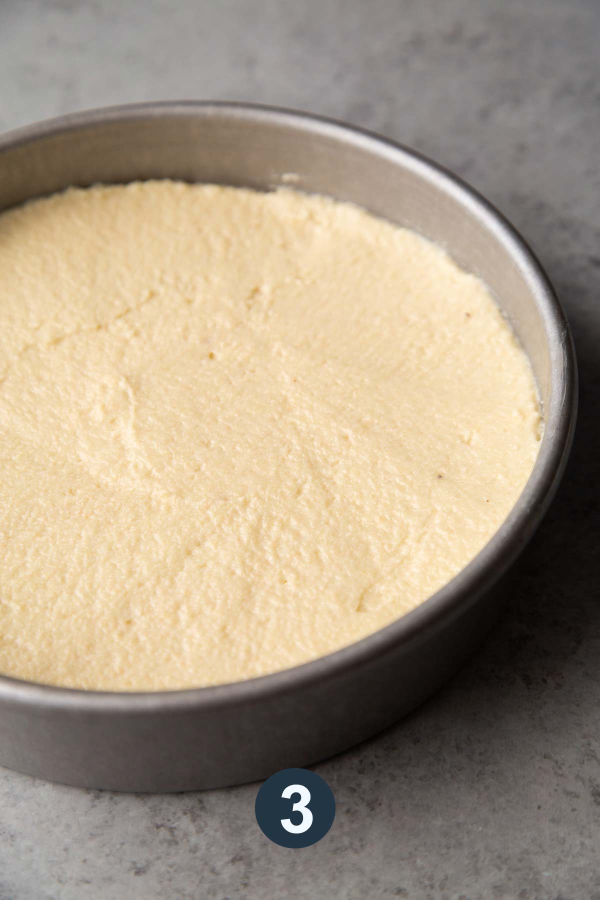 spread almond cake batter into round cake pan.
