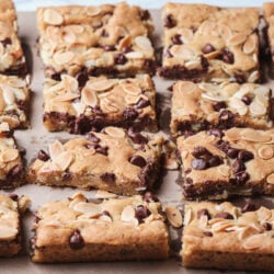 almond chocolate chip cookie bars arranged on parchment paper.
