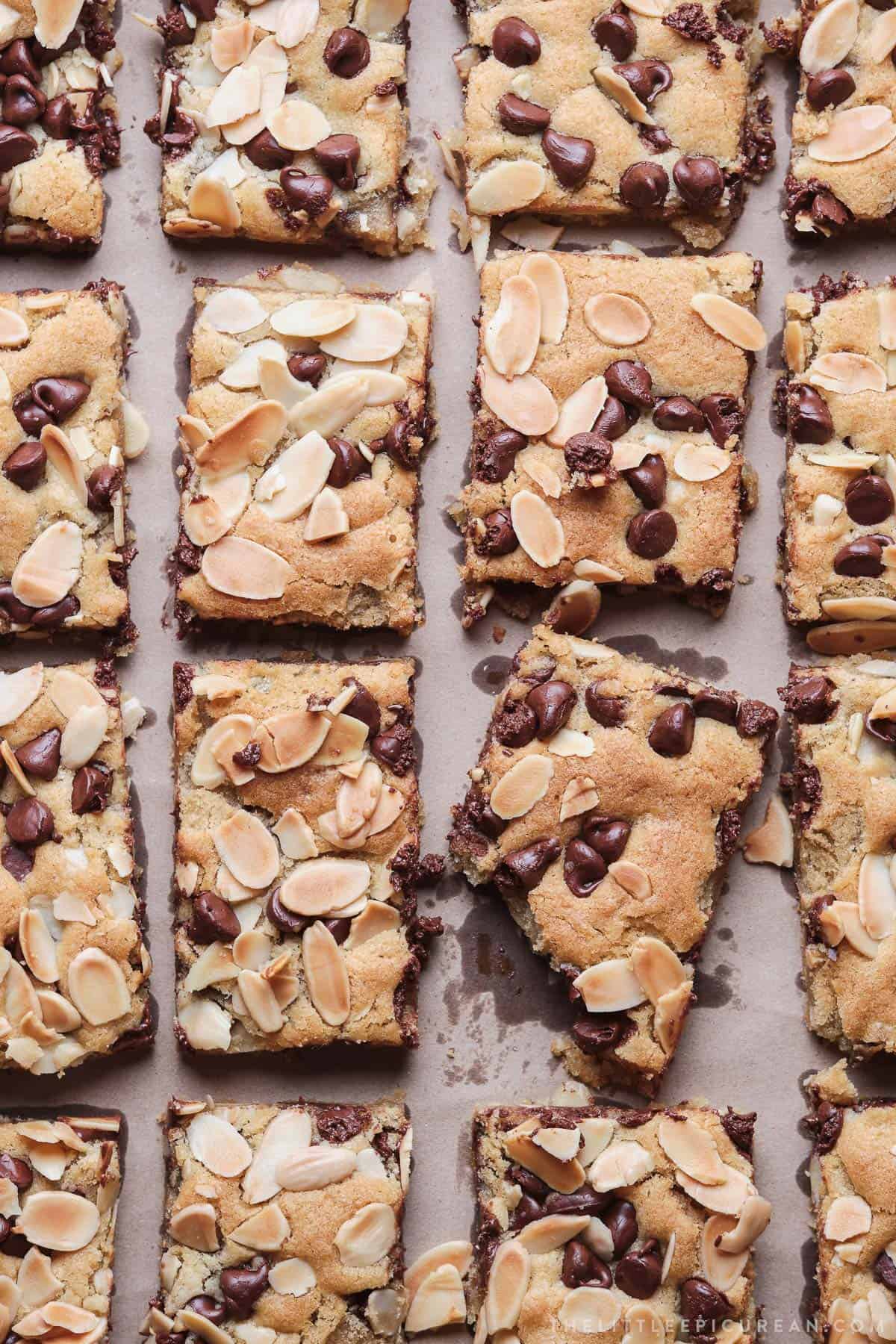 overhead of sliced almond chocolate chip cookie bars on parchment paper.
