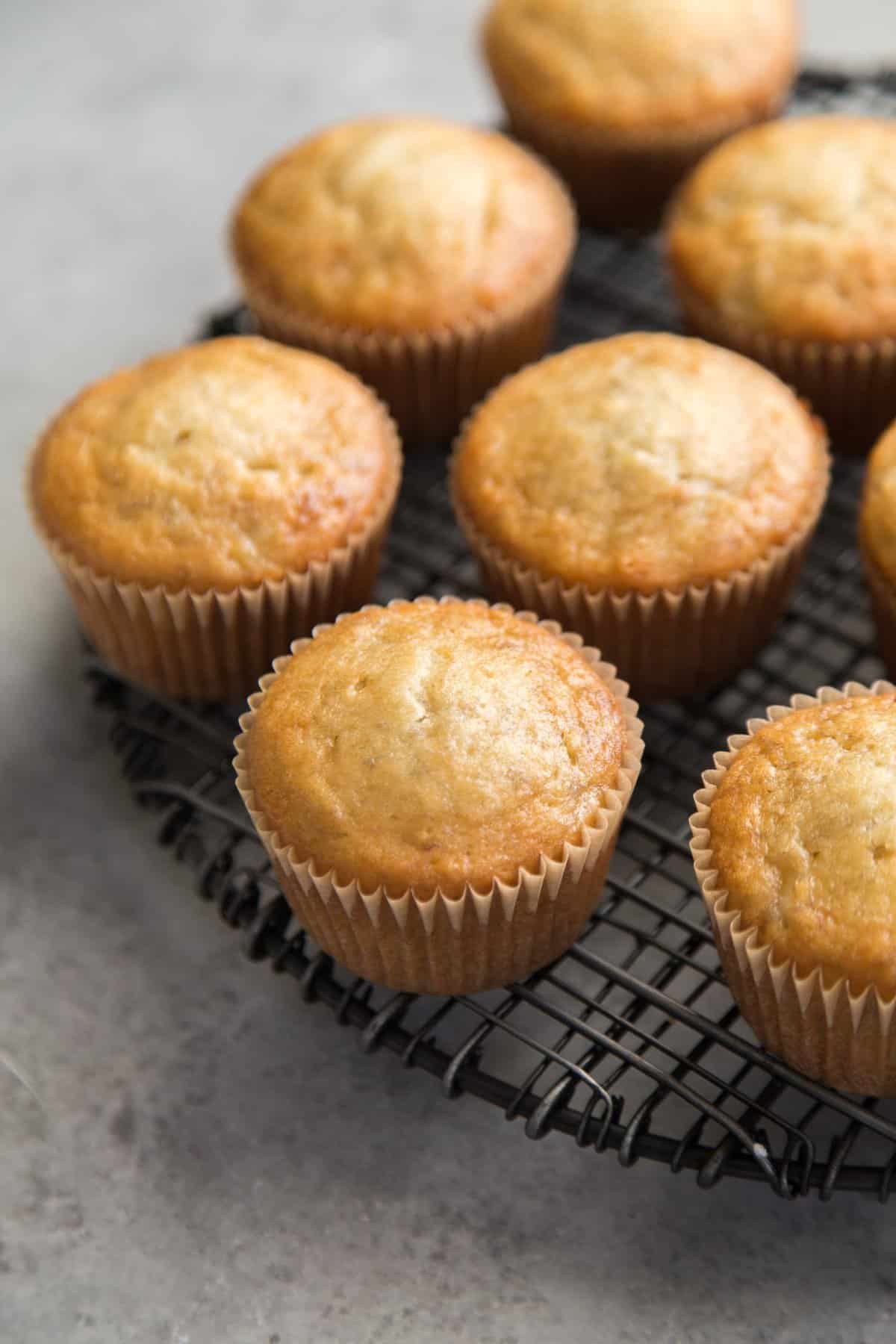 unfrosted banana cupcakes on black wire rack.