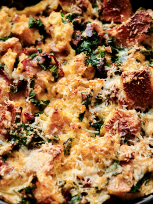 close up of savory parmesan bread pudding featuring kale and bacon.