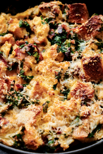 close up of savory parmesan bread pudding featuring kale and bacon.