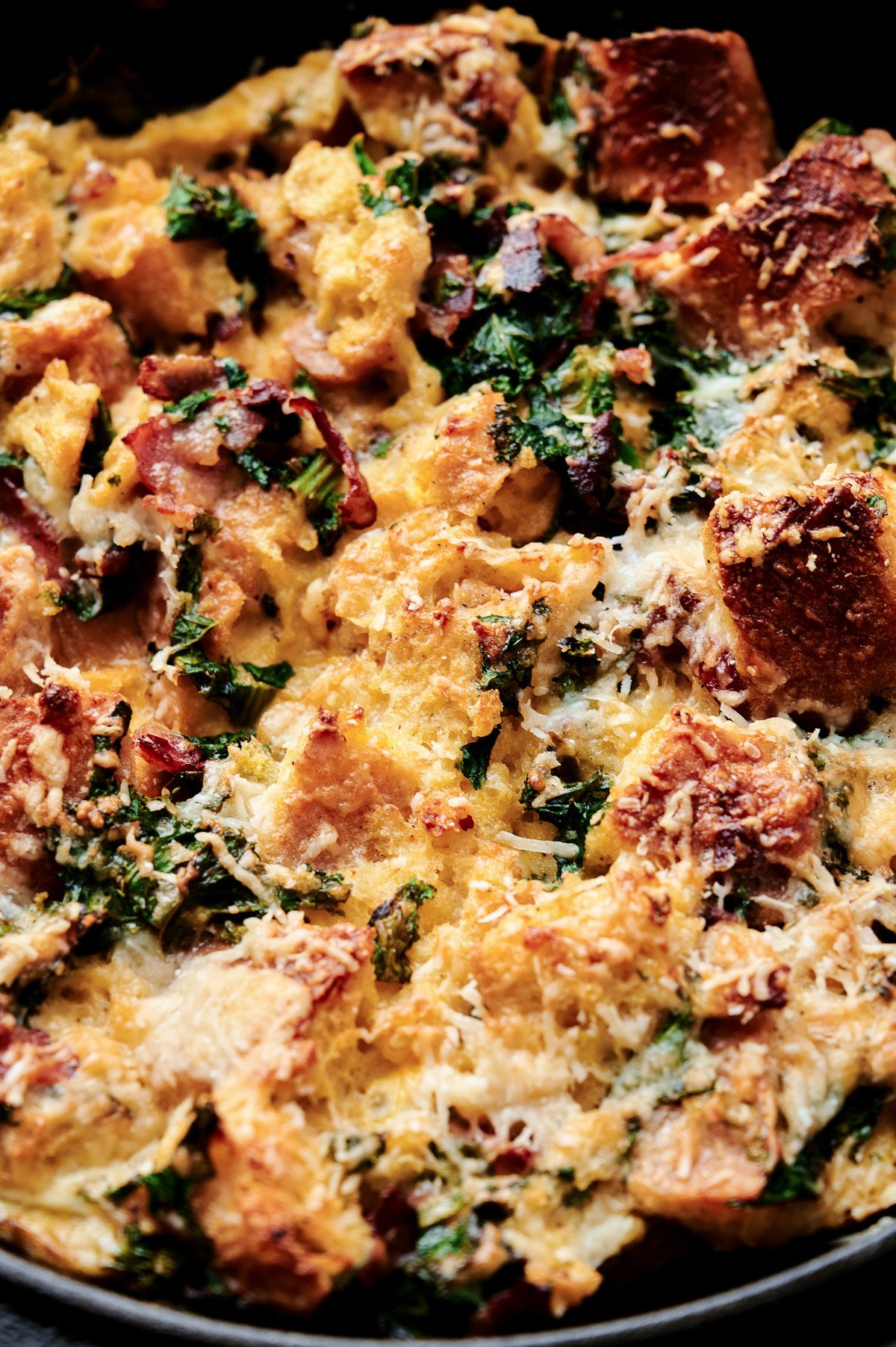 close up of Savory Parmesan Bread Pudding with Bacon, Kale, and Rosemary.