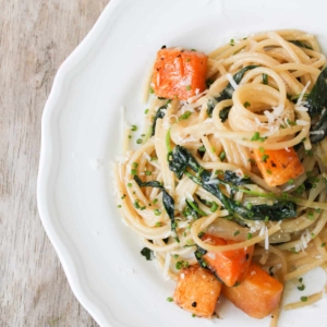 brown butter spaghetti with roasted butternut squash served on white plate.