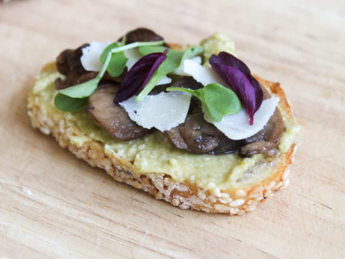 Leek pesto crostini topped with roasted mushrooms, shaved parmesan, and micro-greens.