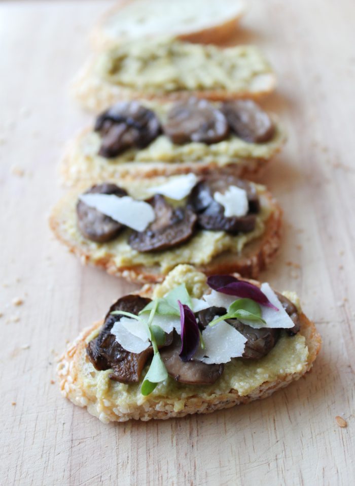 Leek pesto crostini with roasted mushrooms, shaved parmesan, and micro-greens