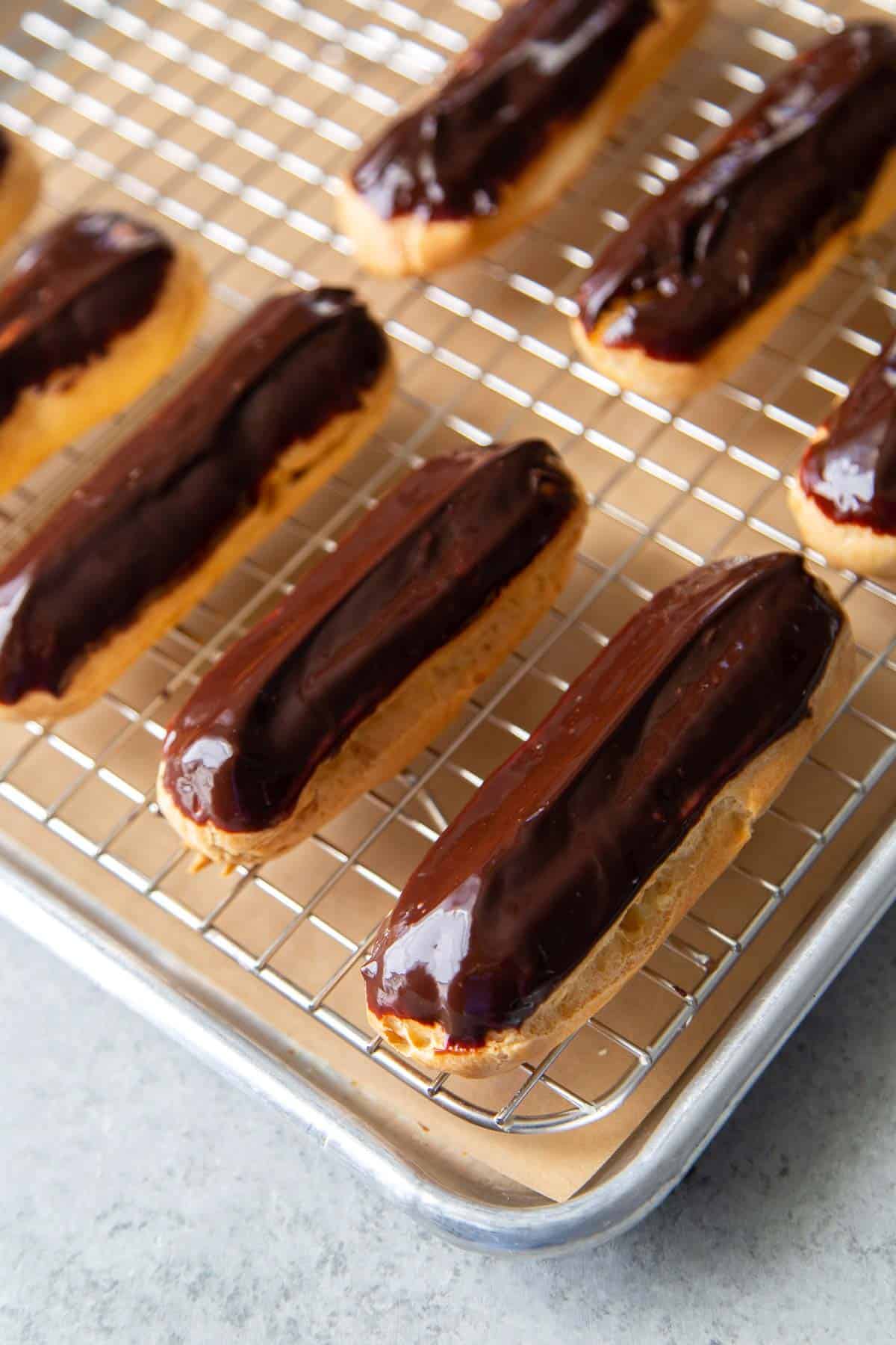 chocolate dipped eclairs on wire rack.