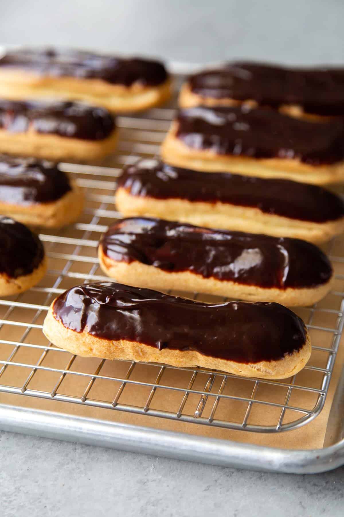 chocolate glazed eclairs on wire rack.