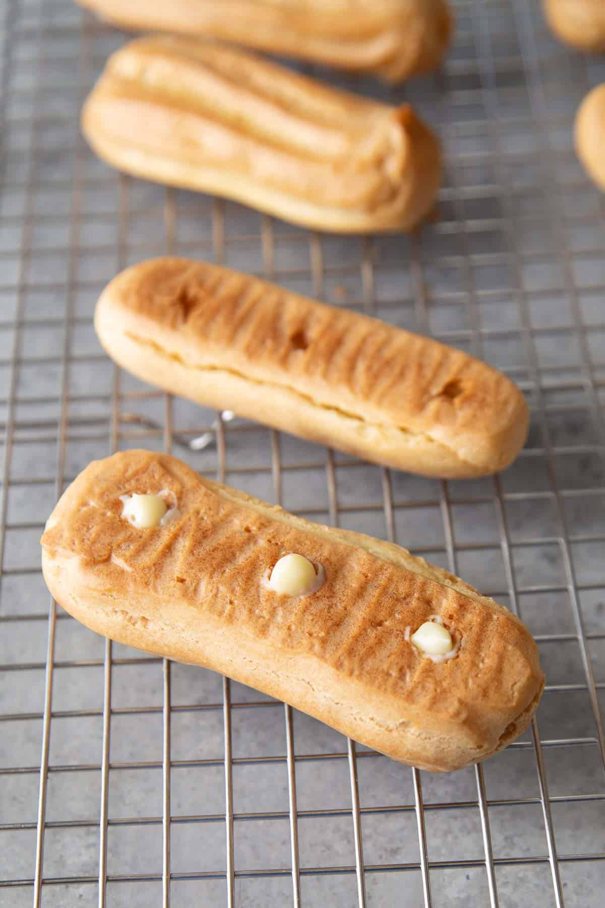 poke three holes on the bottom of eclair and fill with pastry cream.