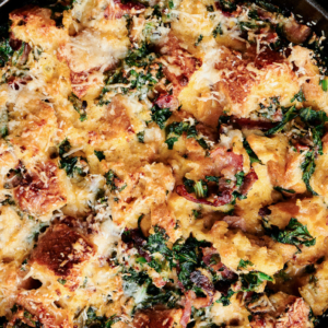 savory bread pudding featuring bacon and kale in black cast iron pan.