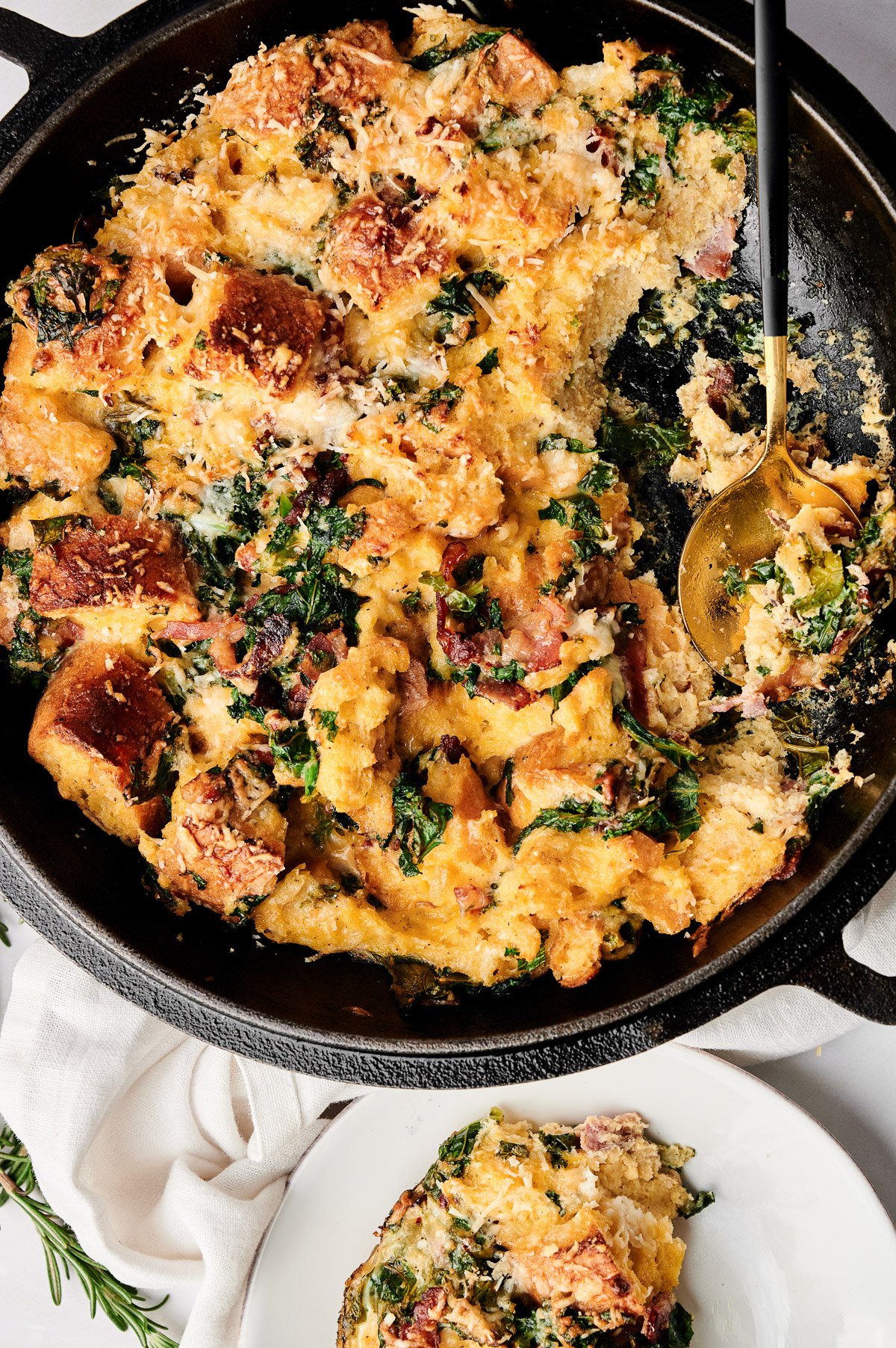 overhead of savory parmesan bread pudding in black pan.