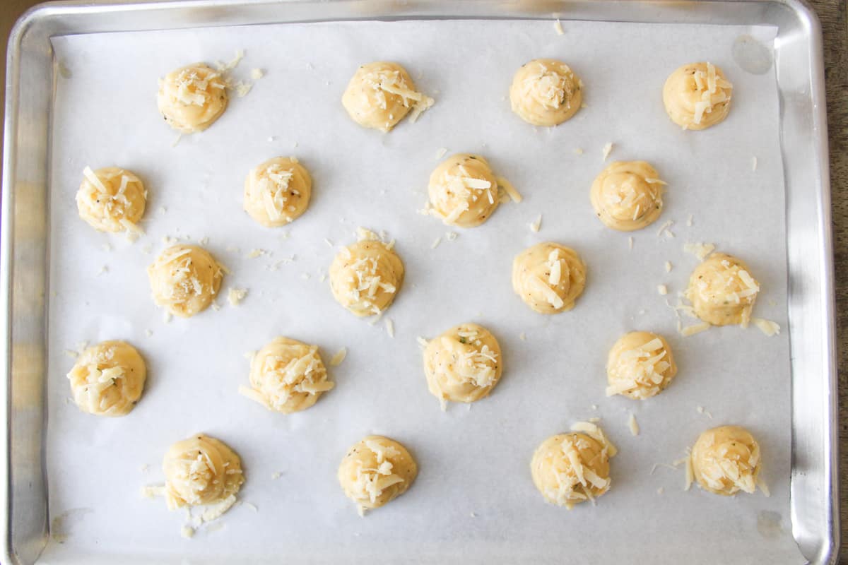 piped gougeres on sheet tray before baking. 