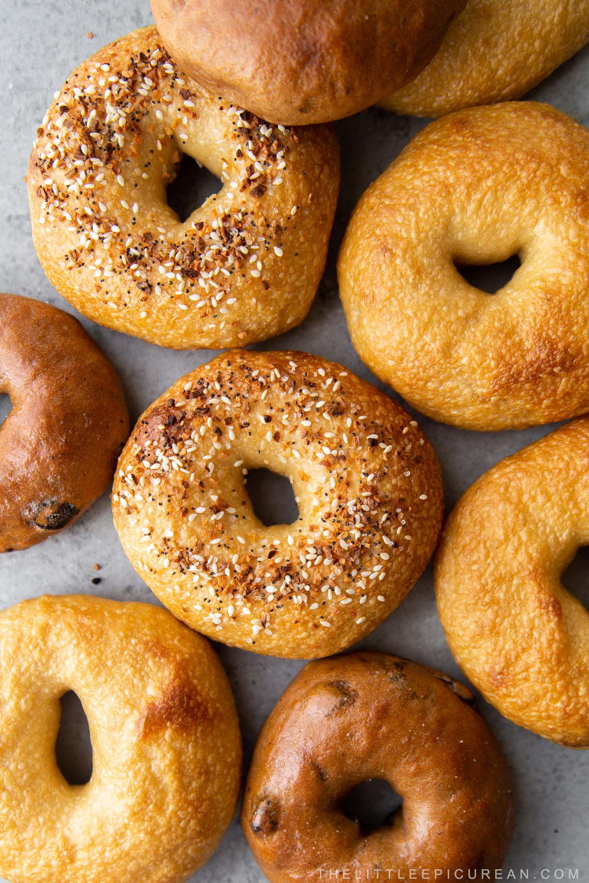 assorted bagels including plain bagels, everything seasoning, and cinnamon raisin bagels.