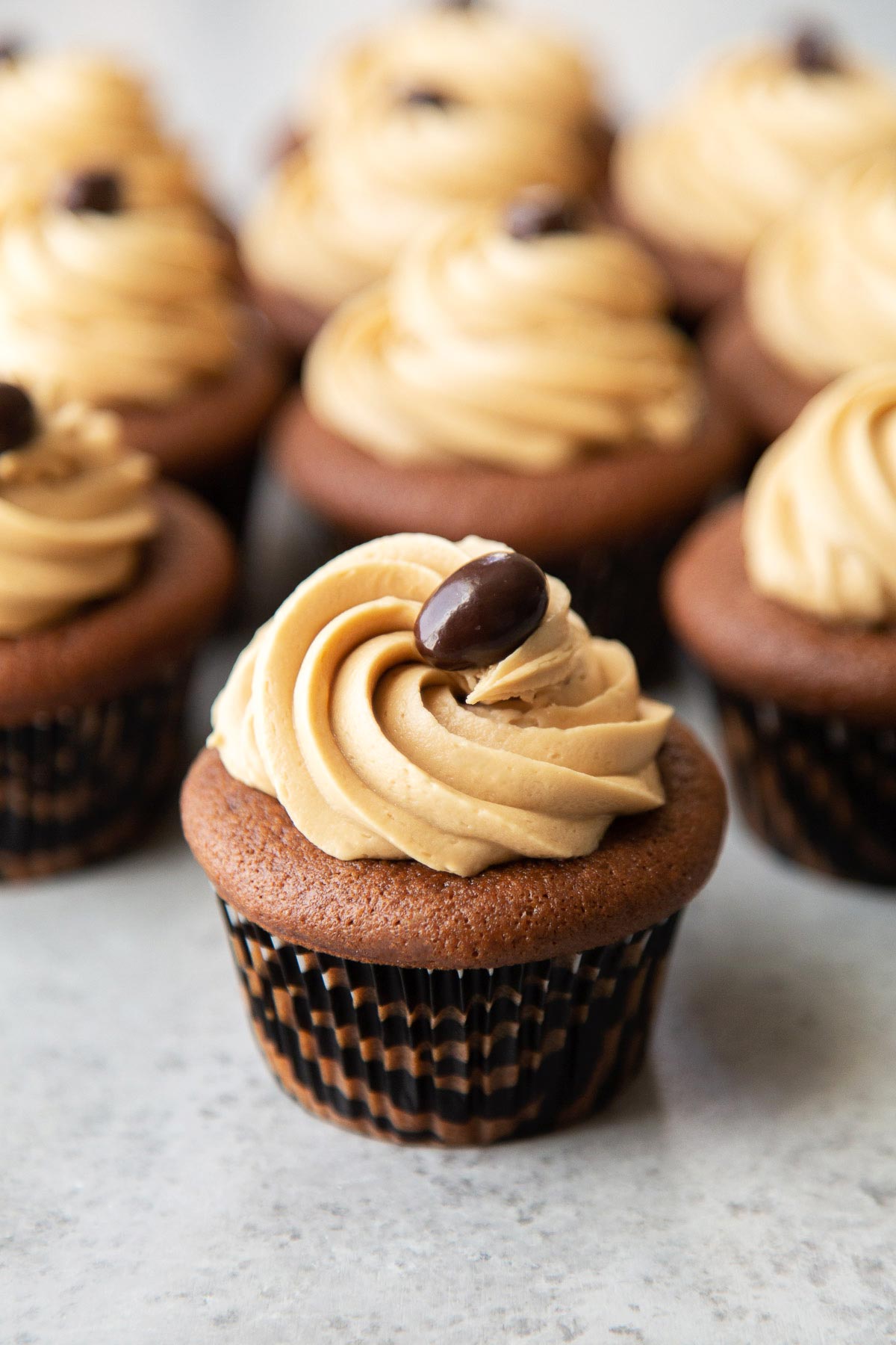 close up of mocha cupcake topped with espresso buttercream garnished with chocolate covered espresso bean.