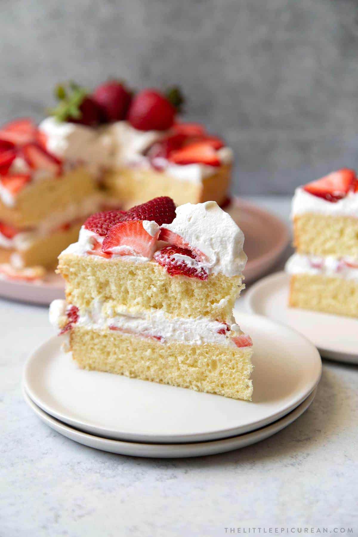 strawberry cake slice with whipped cream frosting.