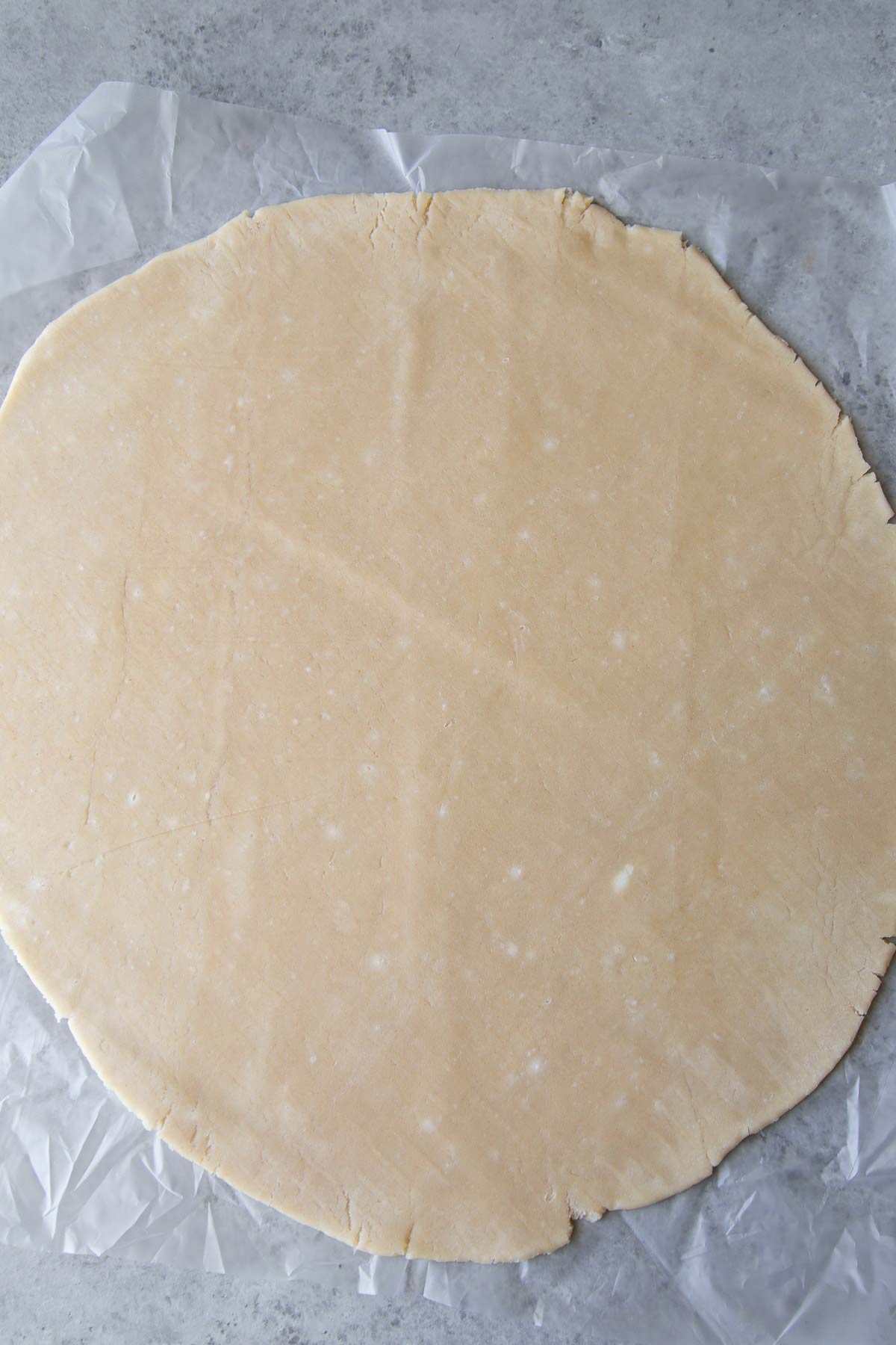rolled out pie dough with flecks of butter.