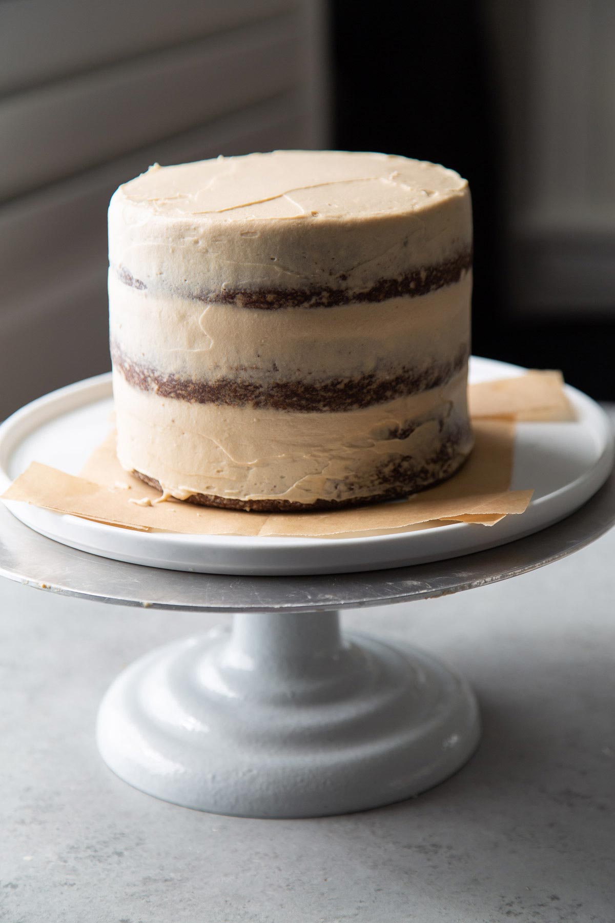 stack three layers of gingerbread cake and crumb coat with brown sugar cream cheese frosting.