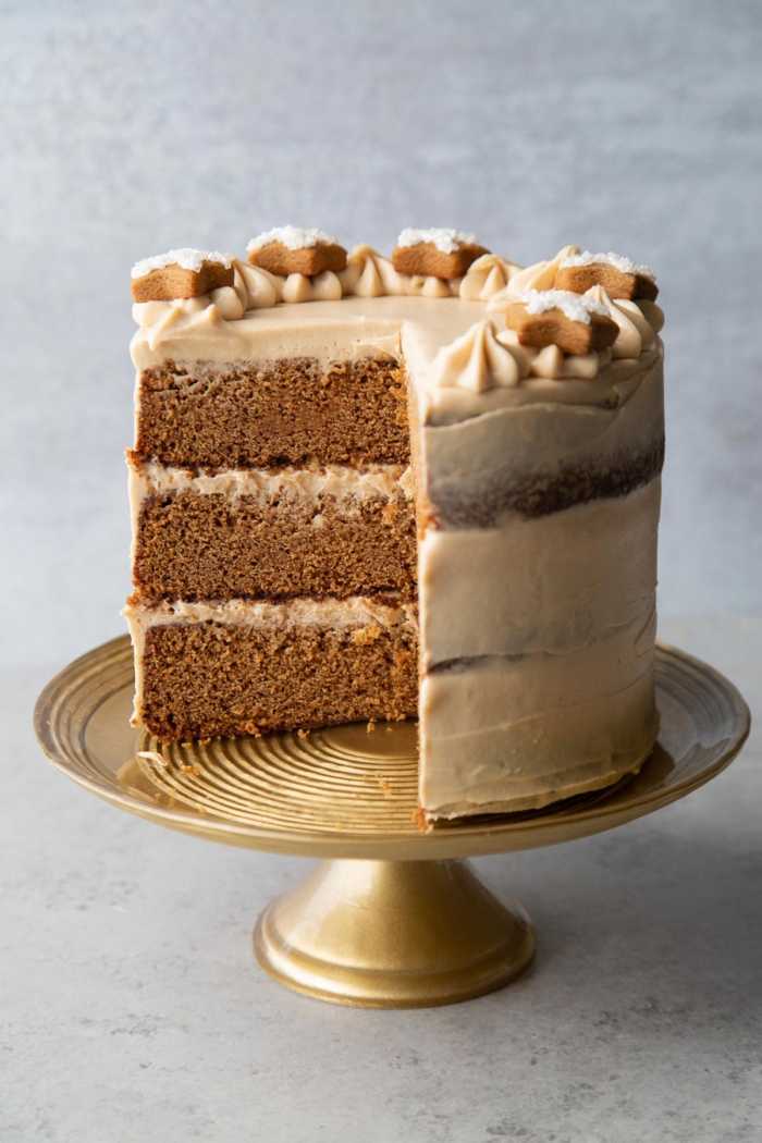 interior shot of layered gingerbread cake with brown sugar cream cheese frosting on gold cake stand.