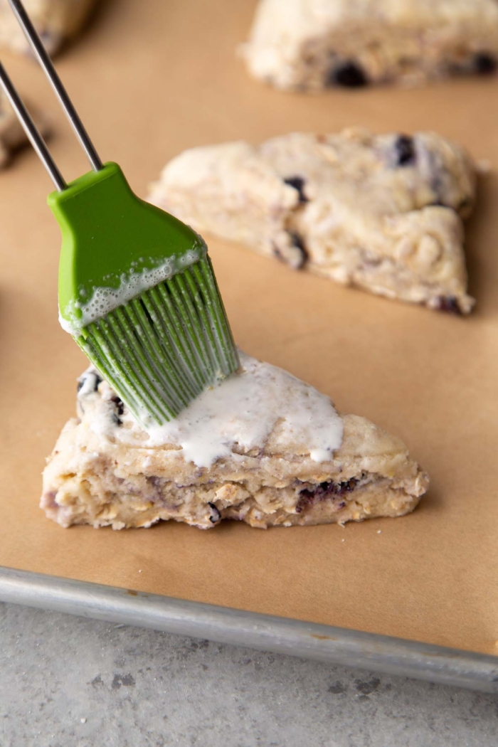 place scone wedges on parchment lined baking sheet and brush top with heavy cream.