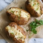 three pieces of twice baked ranch potatoes on marble slab.