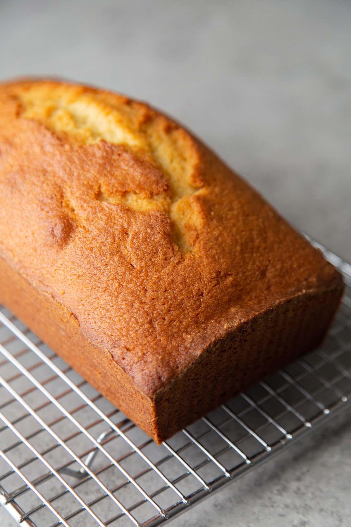 almond pound cake loaf cooling on wire rack.