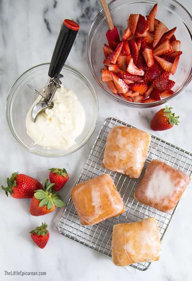 strawberry shortcake donut components include cream cheese frosting and fresh strawberries. 