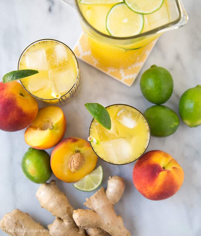 two glasses ginger peach limeade garnished with lime wedge. 