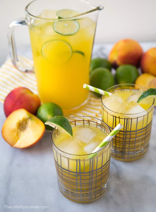 two servings of peach ginger limeade garnished with lime wedge. 