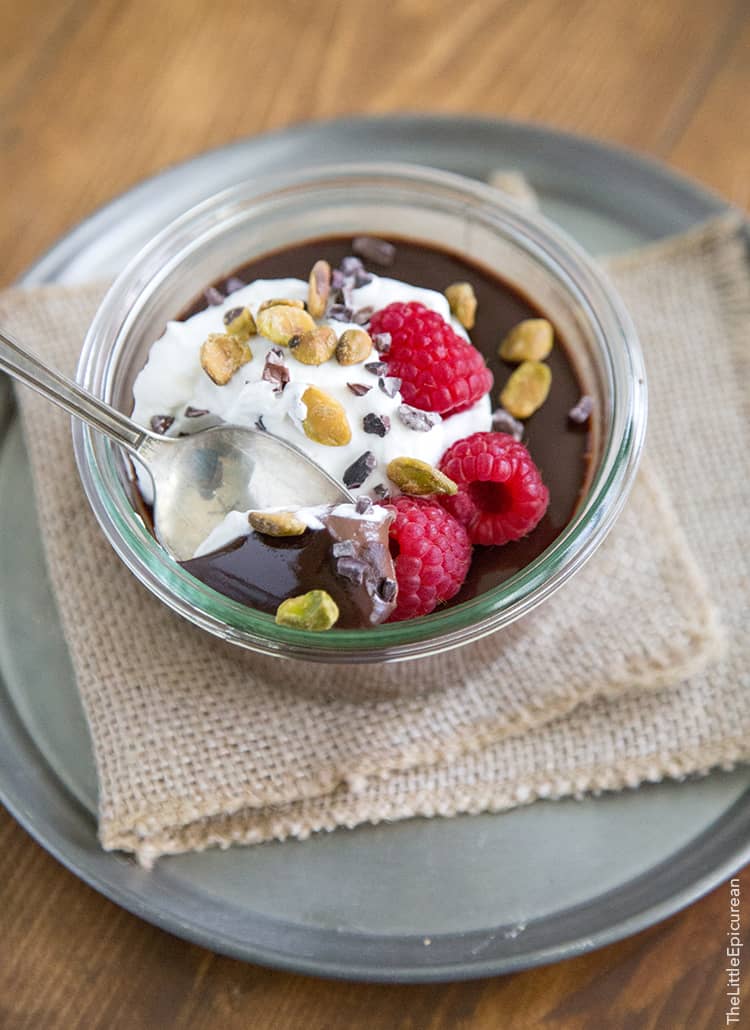 Chocolate Pots de Creme with honey whipped cream, raspberries, pistachios and cocoa nibs