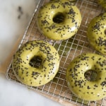 baked matcha doughnuts topped with black sesame seeds on wire cooling rack