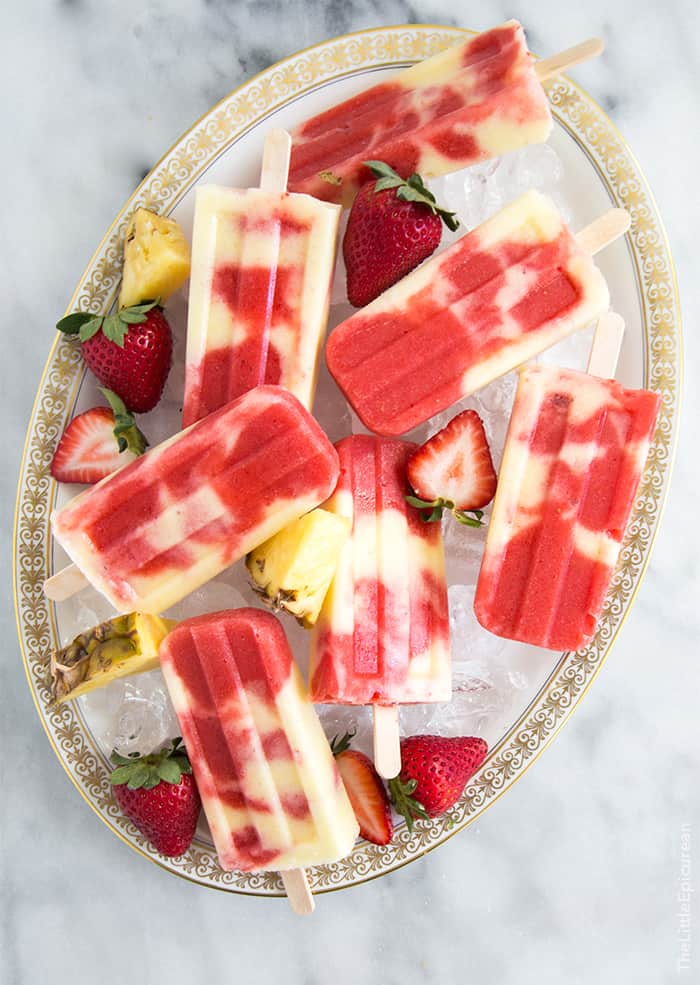 lava flow popsicles combine layers of coconut, pineapple, and strawberry into a visually appealing dessert. 