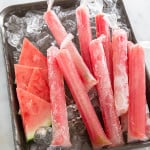 Watermelon Tequila Pops on sheet tray with ice.