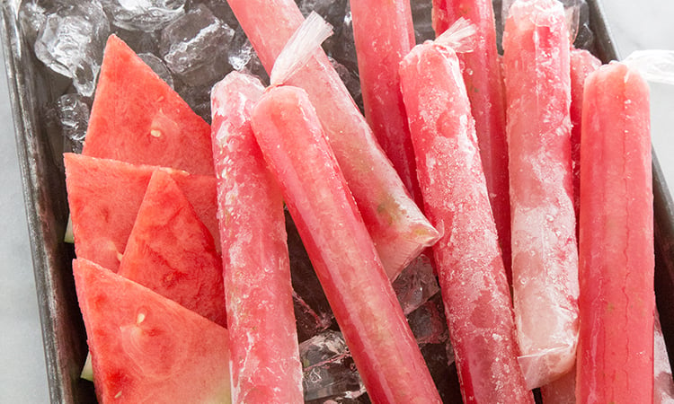 Watermelon Tequila Pops on sheet tray with ice.