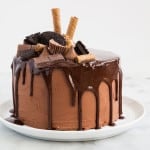 super decadent chocolate layer cake topped with chocolate ganache, chocolate candy bars, and chocolate cookies.